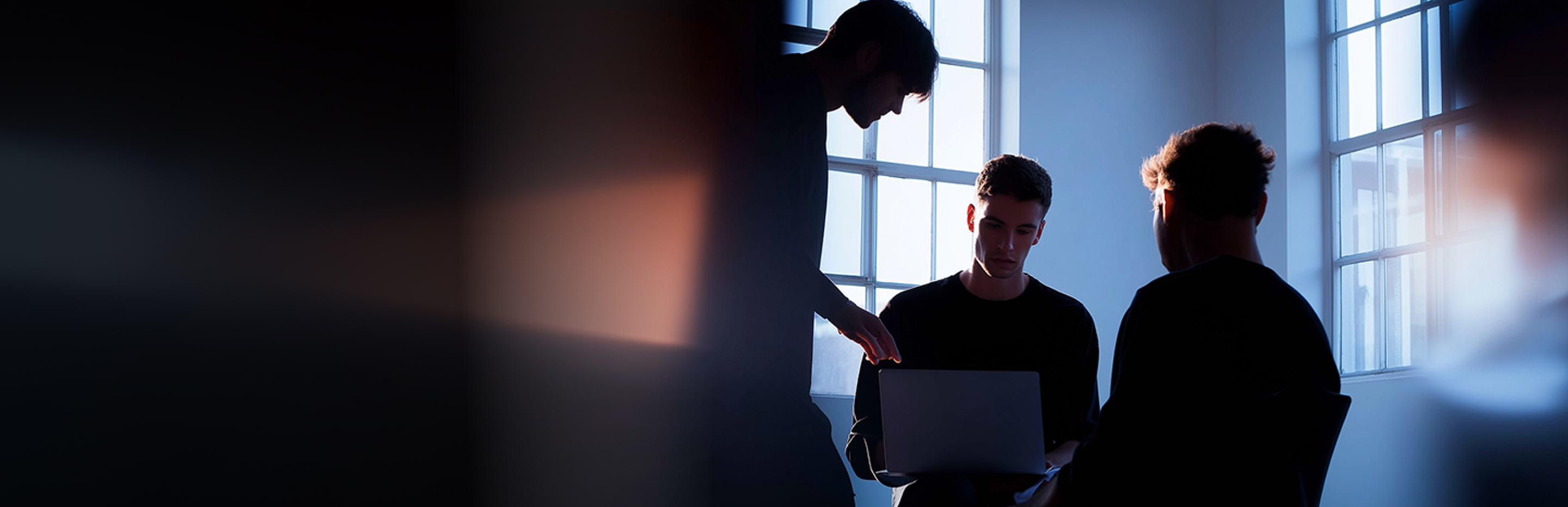 3 men looking at laptop